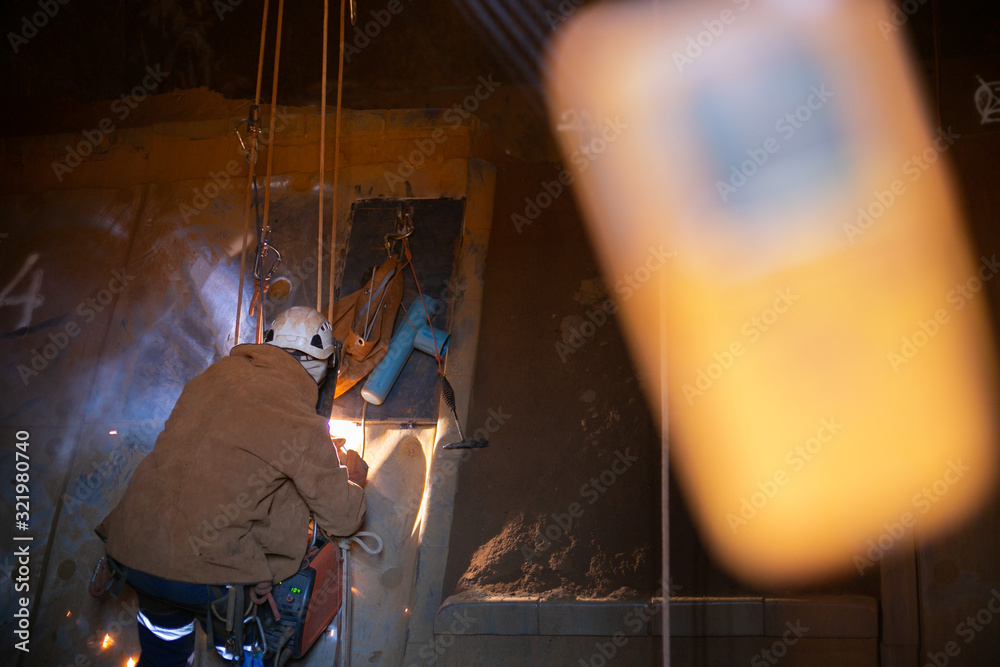 Safety close up shot rope access abseiler stick welder working at