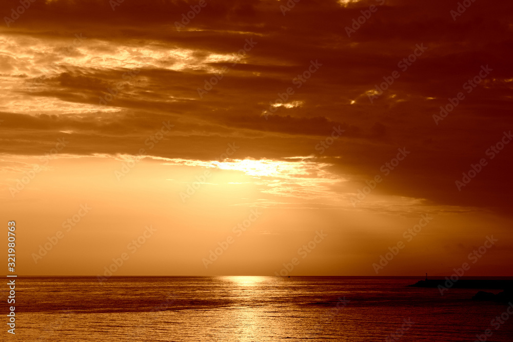 Beautiful sunrise over the sea near the coast of Sicily. Natural background orange color toned