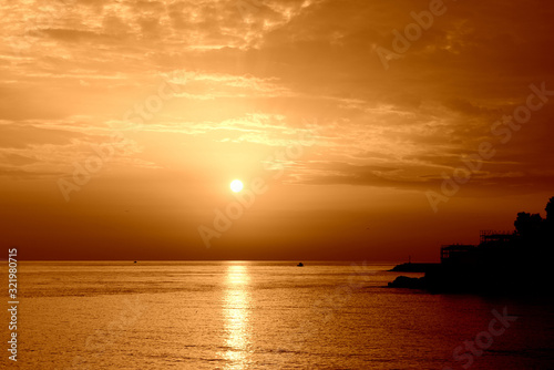Beautiful sunrise over the sea near the coast of Sicily. Natural background orange color toned