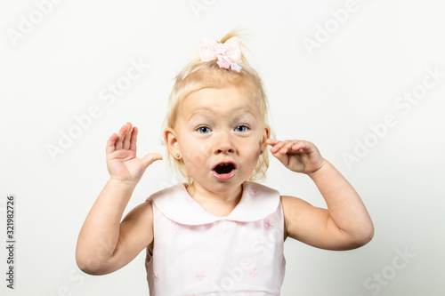 Little girl with a surprised face on a light background. Banner. Concept little model, princess, surprise