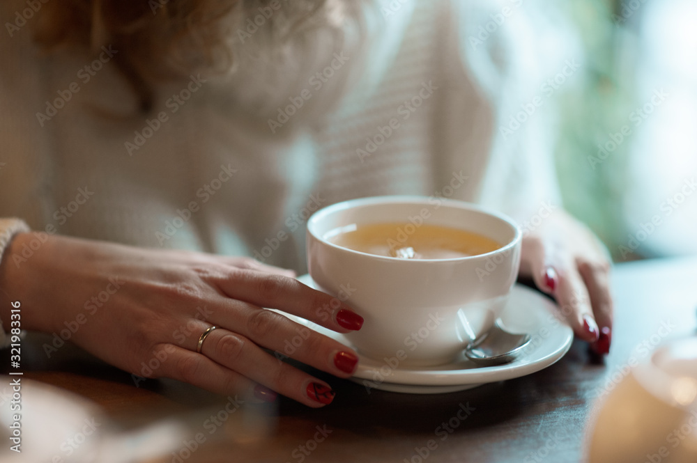 Woman holds white cup with tea