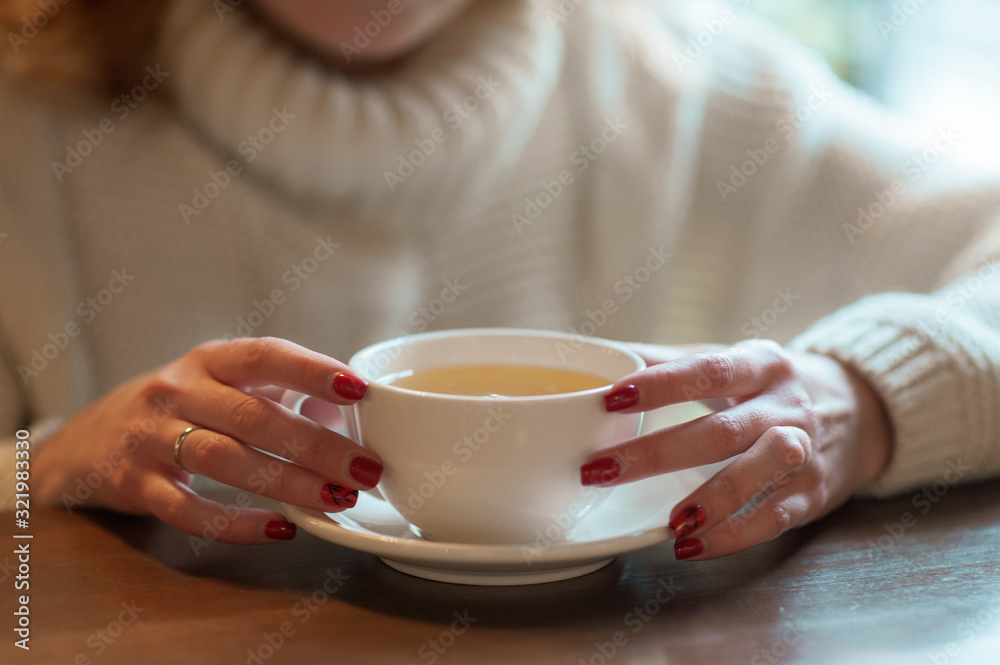 Woman holds white cup with tea Woman holds white cup with tea