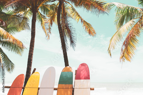 Surfboard and palm tree on beach background.