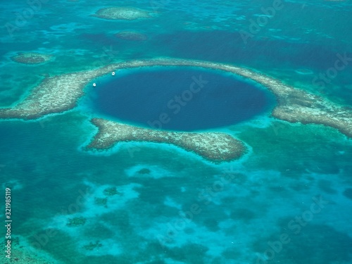 The Great Blue Hole from the air. Lighthouse Reef and Caye / Cay off Belize coast. Underwater Cenote Cave that collapsed. Limestone cave.