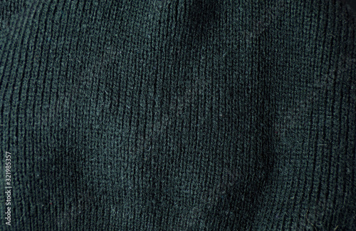 Black knitted sweater. Background and texture of a winter jacket close-up.