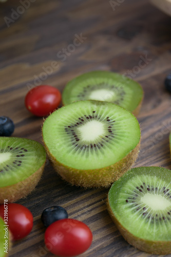 Delicious and healthy kiwi and pineapple fruit on wooden background.