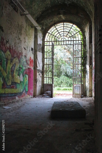 2019.09.28 - Limbiate, Milan, Italy, photographic reportage asylum in Mombello, abandoned psychiatric hospital abandoned mattress in the entrance of the structure, entrance with ruined walls and writi