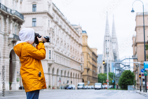 Photography photographer tourist taking picture of city street with votive church on backgro