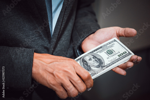 Businessman with money in hand, US dollar,investment, success and profitable business concepts.