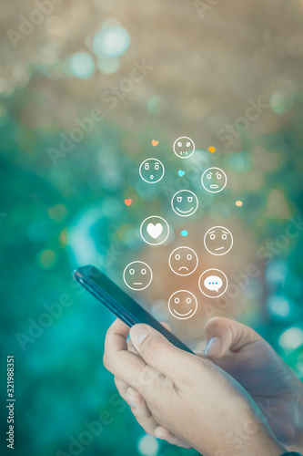 Person using a social media marketing concept on mobile phone with notification icons of like, chat, message and comment above smartphone screen.