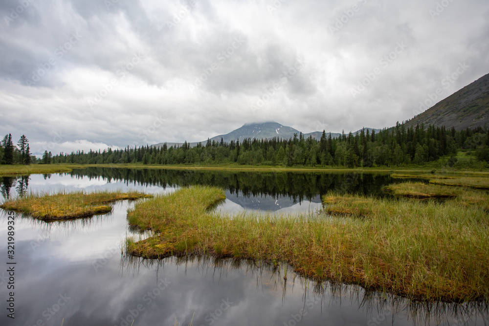 Mountain lake in the taiga. Mountains of the Subpolar Urals.