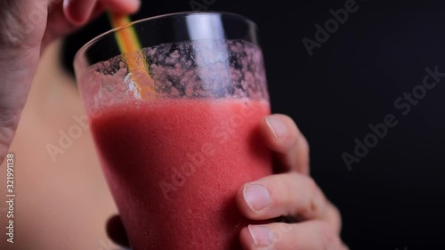 Pretty woman drinking strawberry smoothie from straw 