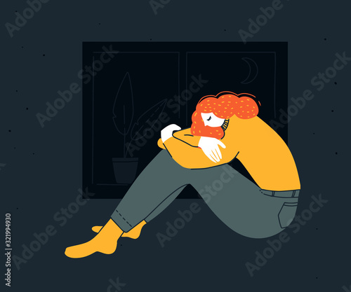 Sad young woman sitting hugging her knees at night. Depression illustration, insomnia disorder. Unhappy redhead girl in yellow shirt at home.