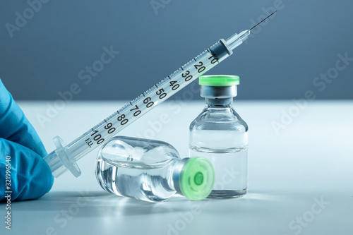 Vaccine in vial and syringe close-up on a white table gray background, medical concept, laboratory, subcutaneous injection vaccination, dose. Disease treatment immunization.