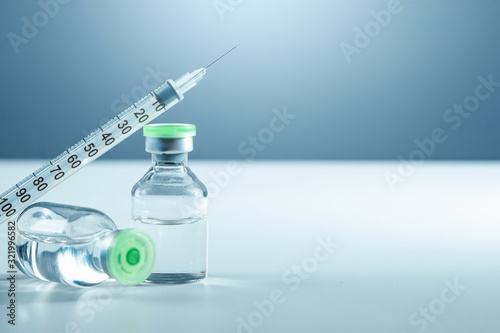 Vaccine in vial and syringe close-up on a white table gray background, medical concept, laboratory, subcutaneous injection vaccination, dose. Disease treatment immunization. photo