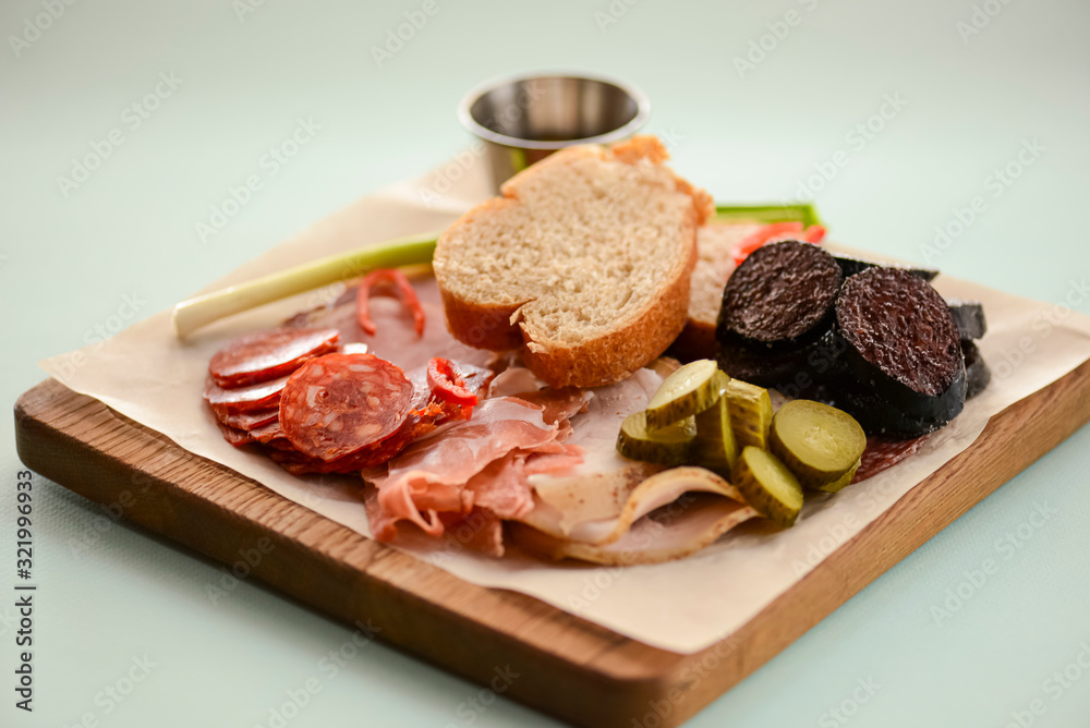 Variety of sausage products, close-up shot. Ham, prosciutto, salami, sausage with bread and pickles and sauce.