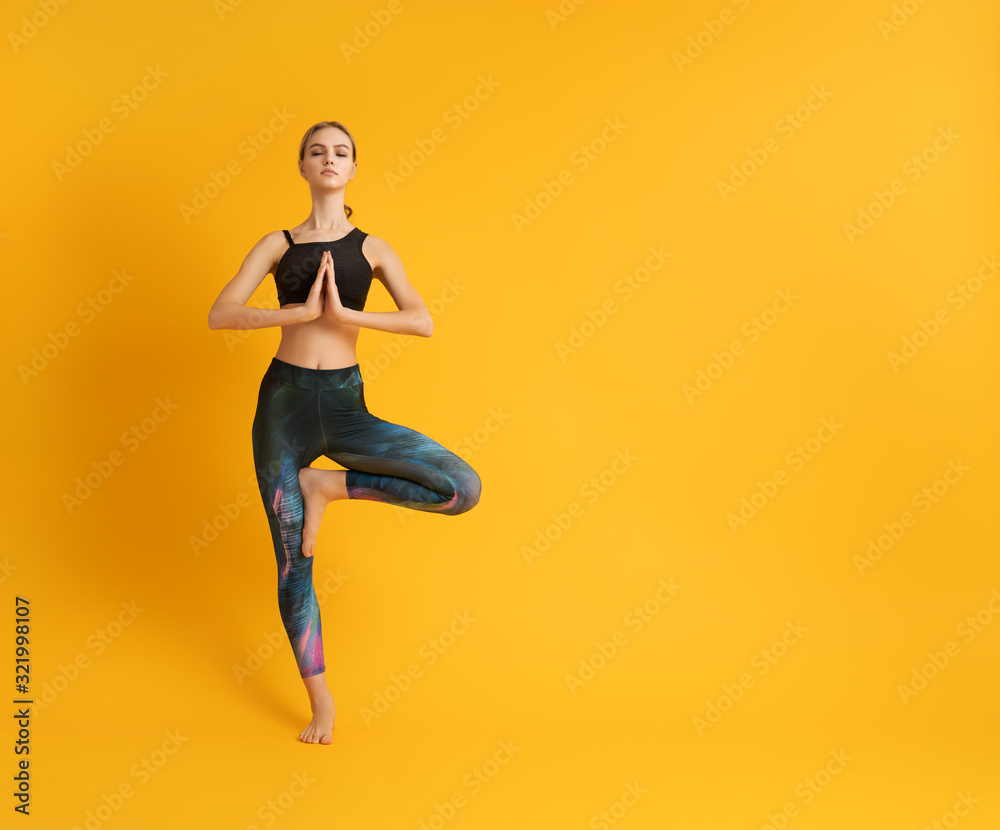 Woman is practicing yoga and meditation - obrazy, fototapety, plakaty 