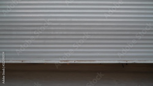 factory door is closing.background of the sliding and dirty steel sliding door is closed.