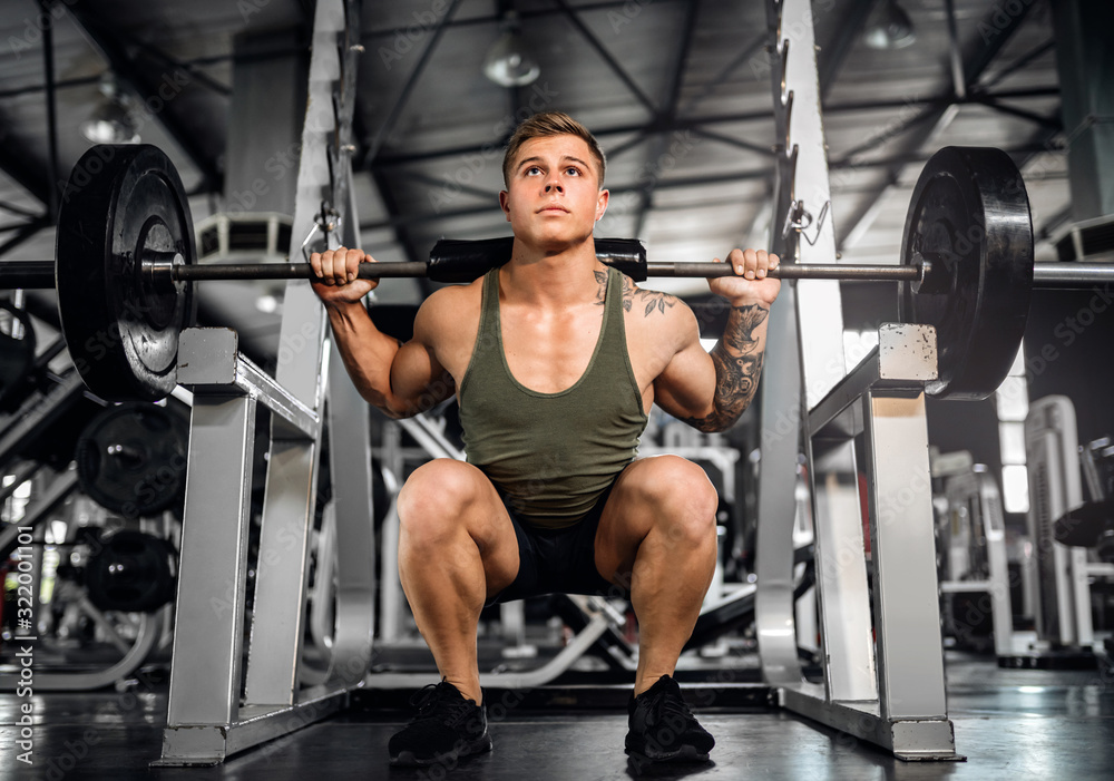 Young attractive muscular gen z body builder doing back squats Young attractive muscular gen z body builder doing back squats