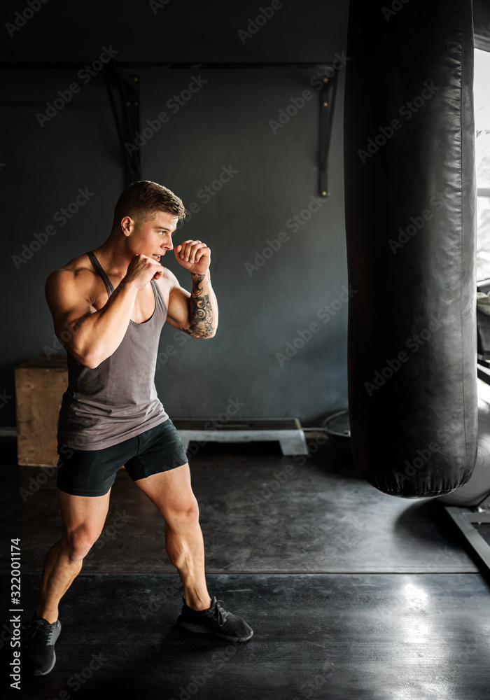 Young gen z boxer training his form. Standing and posing before workout with dramatic lighting