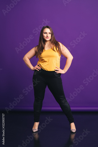 Plus size fashion model in casual clothes, fat woman on purple background © staras