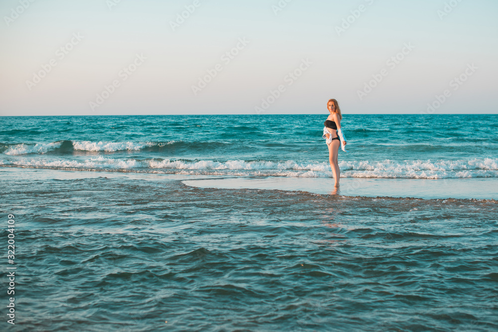 Travelling and adventure concept. Sea view, girl rest at sea store. Pretty american or european woman in swimwear