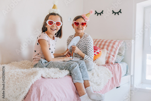 Kids paljamas party in white bedroom interior