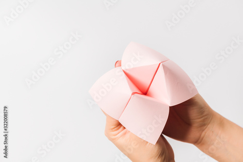 Hand in a paper fortune teller isolated on white background. photo