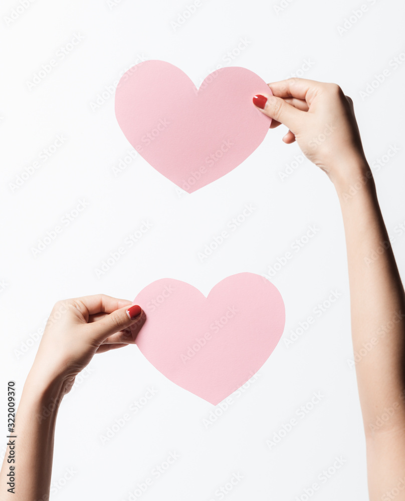 Close up women holding pink blank paper with heart shape on white background. Close up women holding pink blank paper with heart shape on white background.