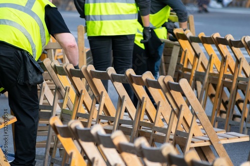 Foto Closeup shot of security guards in yellow uniforms arranging chairs for an event