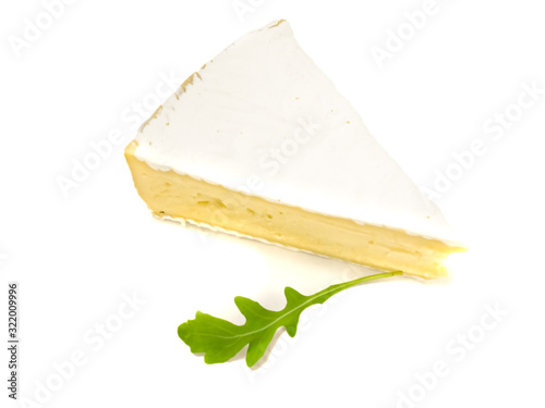 Brie type of cheese. Fresh Brie cheese and with green leavesrucola.