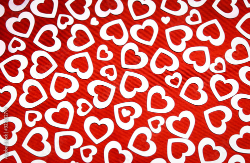 Full frame Valentine's Day background of silver hearts on a textured red background