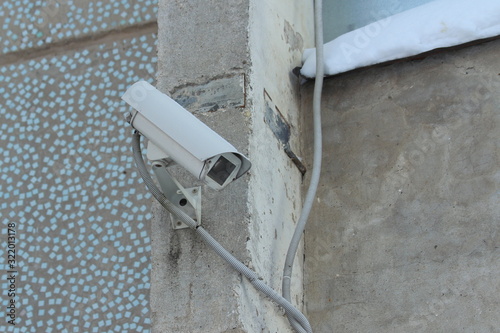 Surveillance camera mounted on tiled wall of house
