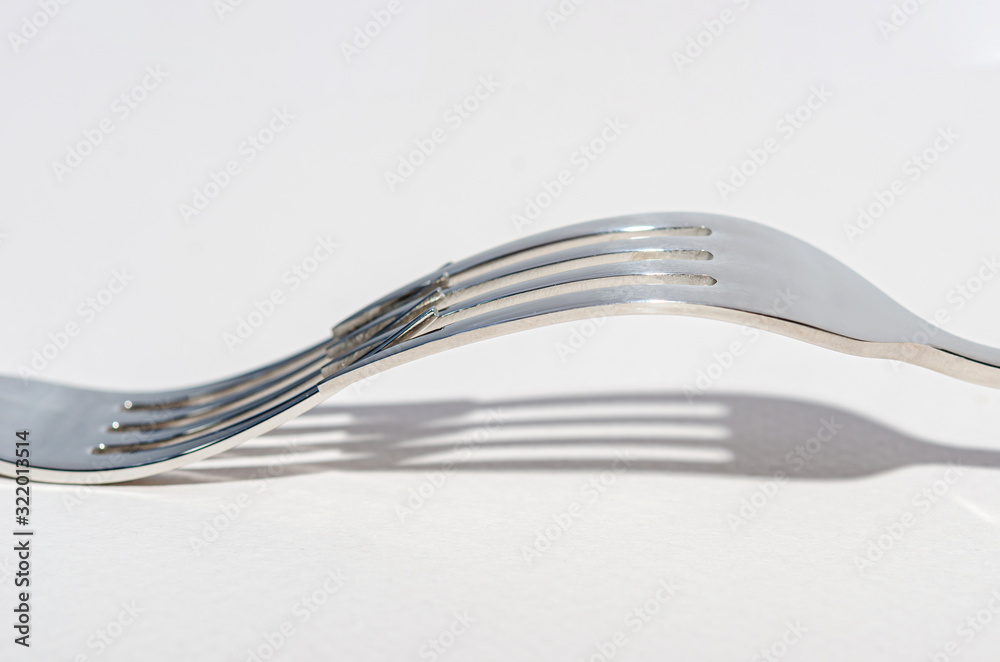 Two metal shiny forks on a light background. Two metal shiny forks on a light background.