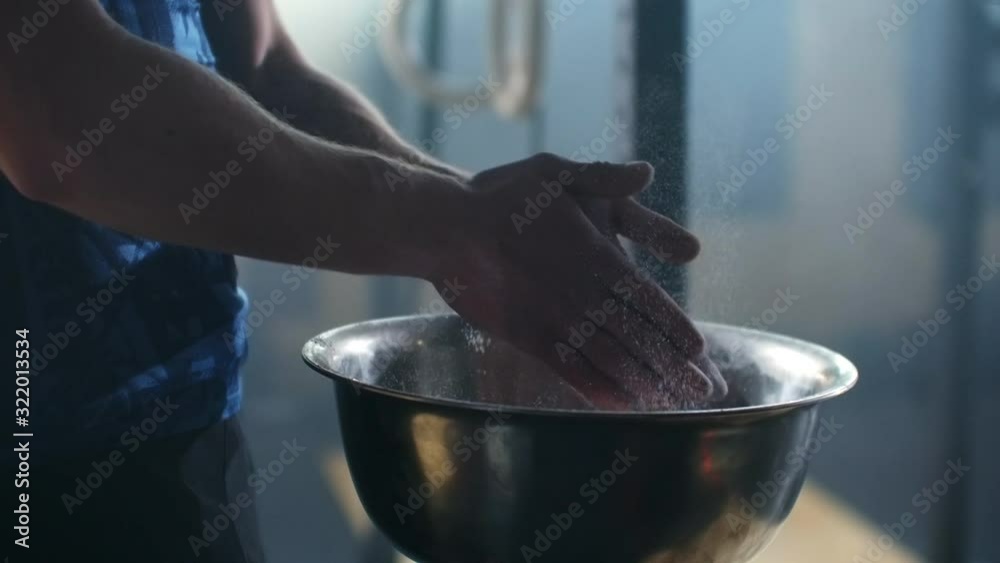 SLOW MOTION closeup of an athlete hands clapping with white chalk powder that explodes in slow motion particles of dust. SLOW MOTION closeup of an athlete hands clapping with white chalk powder that explodes in slow motion particles of dust.