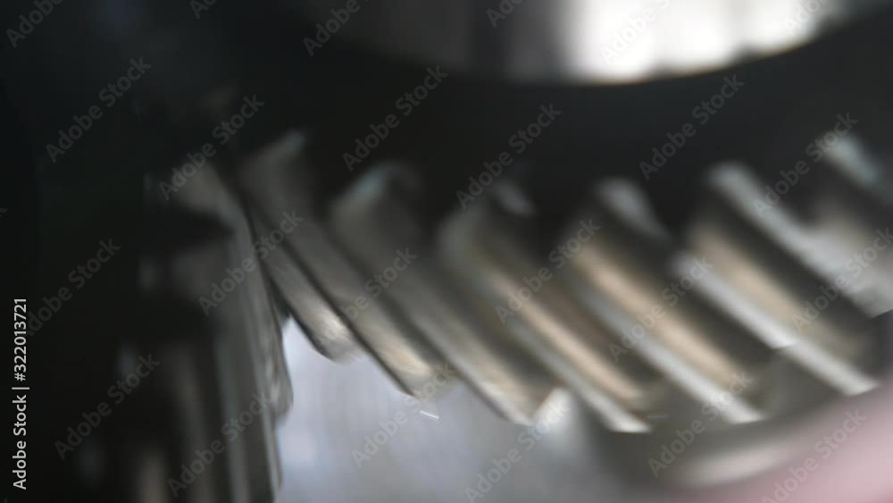Rotating teeth of two large cogs working aslant in a contemporary car ...