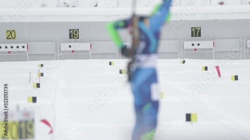 Footage of a biathlon contestant shooting in standing position to the target
