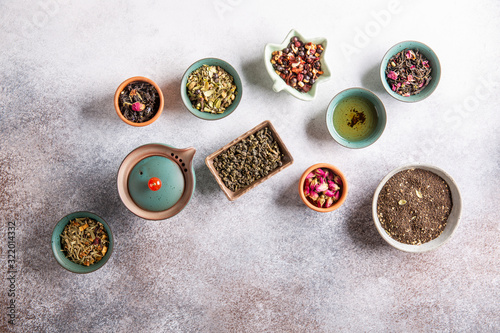 Assortment of dried tea in ceramic bowls. Black, green and herbal tea collections. Top view, copy space. Food background.