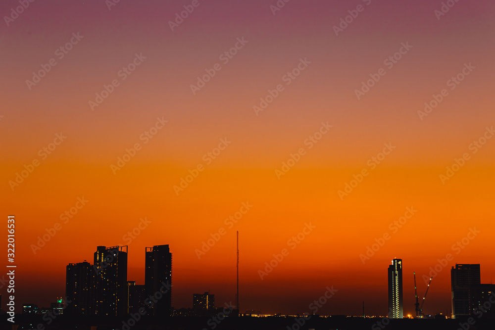 Silhouette dusk city quiet calm sunset sky no cloud orange sky view space for text.