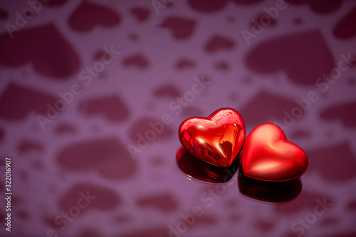 Two red hearts against holiday defocused background. Valentines day concept.