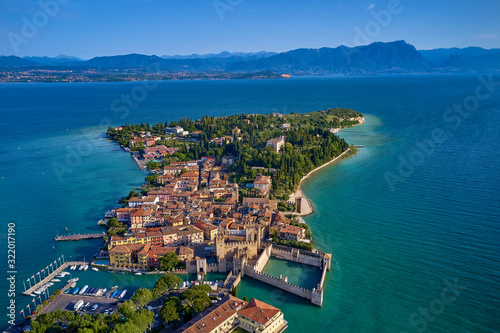 Unique view. Aerial photography, the city of Sirmione on Lake Garda north of Italy. In the background is the Alps. Resort place. Aerial view. Sirmione Castle,