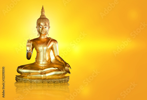 Golden Buddha statue with glittering aura on a golden yellow background for design and a beautiful background.