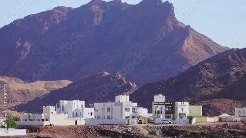 Typical Omani Architecture with Mountains in Background. Standard White Arabian Houses in Surburbs of Muscat photo