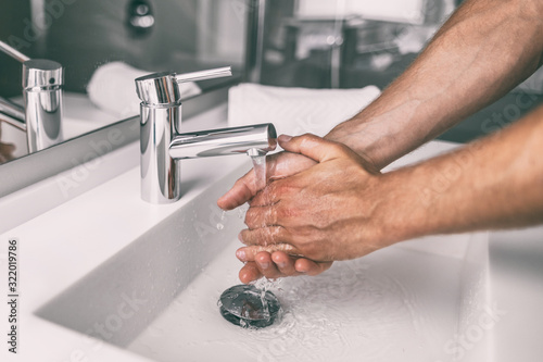 Washing hands rubbing with soap man for winter flu virus prevention, hygiene to stop spreading germs.