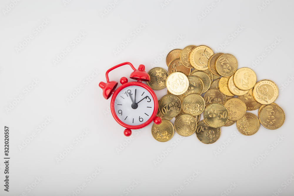 Red clock with Coins on wooden backgrounds. Saving money and finance business concept. Business finance and save money for prepare in the future. Time is money concept.