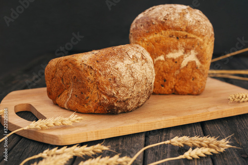 Fresh homemade bread with sunflower seeds, isolated on a wooden background. Side view, top view, close-up view. Ears of wheat, rye. Healthy diet. Carbohydrates. Cereals. photo