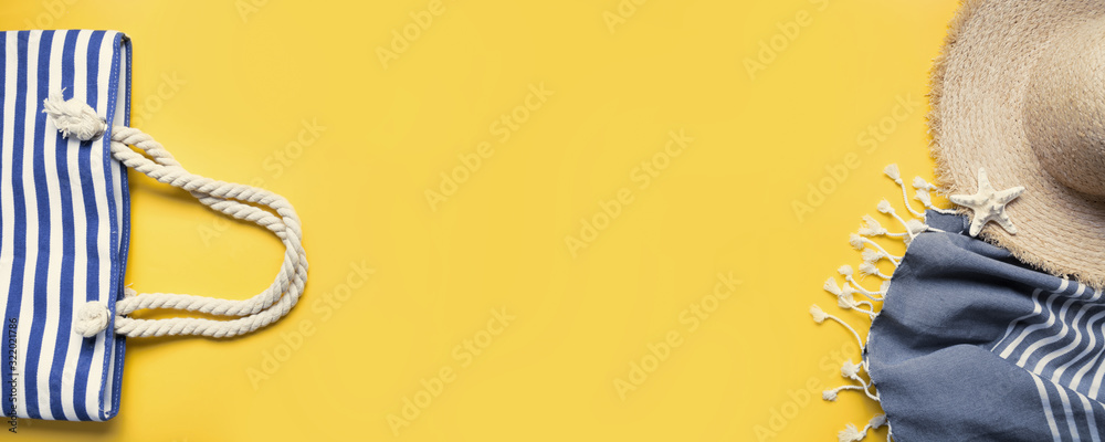 Banner of beach bag, straw sunhat, beach towel on yellow. Summer holiday background. View from above. - obrazy, fototapety, plakaty 