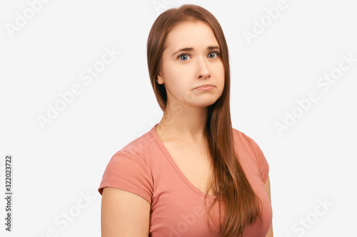 Emotionally wounded woman with sad expression on face, crooked lower lip with disgruntled look. Girl received bad words about work, feels disappointed. isolated on white background in Studio