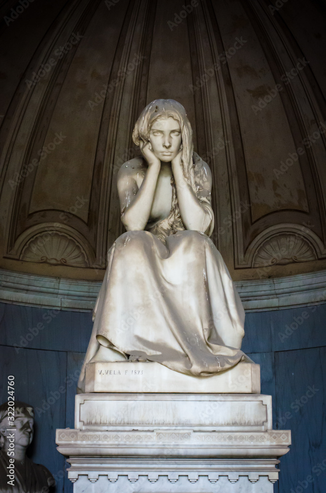 La statua di una donna sconsolata che si tiene il volto fra le mani su una tomba del cimitero monumentale di Bologna La statua di una donna sconsolata che si tiene il volto fra le mani su una tomba del cimitero monumentale di Bologna