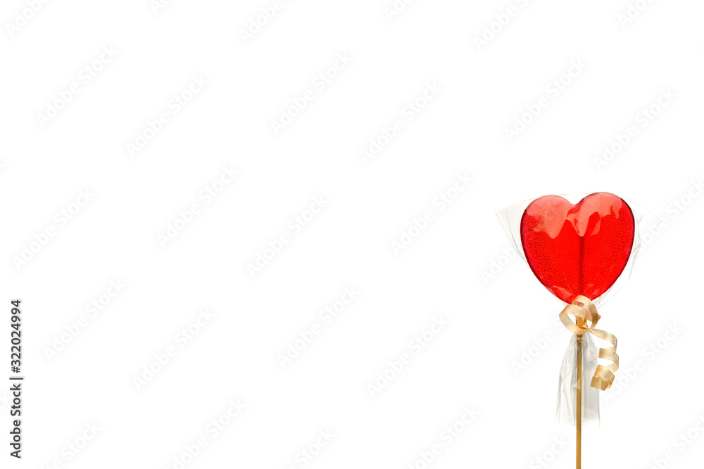 Lollipop. One red heart-shaped Lollipop in transparent packaging right on a white isolated background, left space for text for Valentine's Day. Isolate. Lollipop. One red heart-shaped Lollipop in transparent packaging right on a white isolated background, left space for text for Valentine's Day. Isolate.